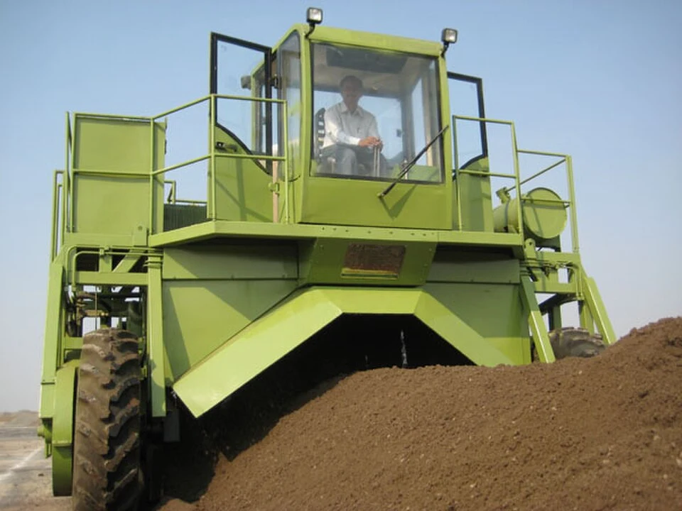 Commercial compost-turning machine working over managed organic material — representative application photograph